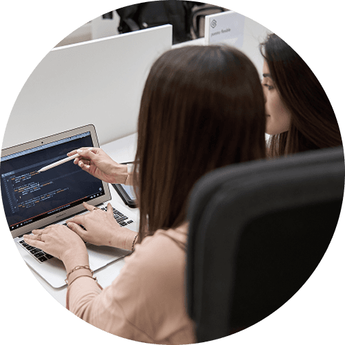 Two UAIOS developers reviewing code together on a laptop